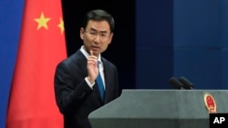 FILE - Chinese Foreign Ministry spokesman Geng Shuang gestures as he speaks during a daily briefing at the Ministry of Foreign Affairs office in Beijing, Sept. 4, 2017.