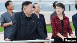 North Korean leader Kim Jong Un and a woman being identified by state TV as his wife 'Comrade Ri Sol Chu,' visit the Rungna People's Pleasure Ground, which is nearing completion, in Pyongyang, July 25, 2012.