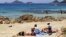 People sit on the Terre Sacree beach in Ajaccio on June 25, 2016 on the French island of Corsica.
