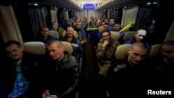 Prisioneros de guerra ucranianos reaccionan en un autobús después de un intercambio, en medio del ataque de Rusia a Ucrania, en un lugar desconocido en Ucrania, en esta imagen difundida el 30 de diciembre de 2024 por el presidente ucraniano Volodymyr Zelenskyy en Telegram. 