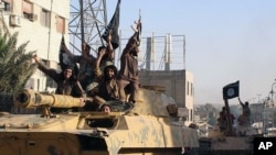 FILE- Fighters from the Islamic State group during a parade in Raqqa, Syria. 