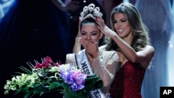 La ex Miss Universo Iris Mittenaere (derecha) coloca la corona a la nueva Miss Universo Demi-Leigh Nel-Peters en la ceremonia realizada en Las Vegas, Nevada, EE.UU., el domingo, 26 de noviembre de 2017. 