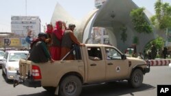 Combatientes talibanes posan en la parte trasera de un vehículo en la ciudad de Herat, al oeste de Kabul, Afganistán, el sábado 14 de agosto de 2021, luego de que tomaron esta provincia del gobierno afgano.