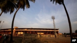 Des jeunes jouent au foot à l'extérieur du stade du 28 septembre à Conakry, en Guinée. AP / Rebecca Blackwell