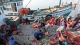 Migrant workers work on fishing boats at a pier in Prachuabkhirikhant province, southern Thailand Tuesday, March 4, 2014.