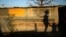 The shadows of a mother and child are cast on a shack in Marikana's Nkaneng township in Rustenburg, 100 km northwest of Johannesburg, August 15, 2013.