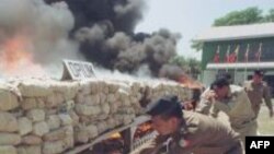 Burmese narcotic control officials put more wood to burn some six tons of seized opium, heroin and other drugs before diplomats, journalists and international business leaders in Rangoon, Burma. (File Photo)