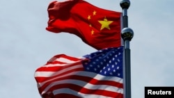 FILE - Chinese and U.S. flags flutter near The Bund before U.S. trade delegation meets its Chinese counterparts for talks in Shanghai, China, July 30, 2019. 