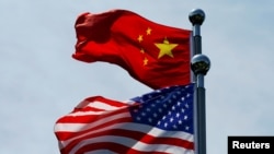 FILE - Chinese and U.S. flags flutter near The Bund before U.S. trade delegation meets its Chinese counterparts for talks in Shanghai, China, July 30, 2019. 