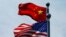 FILE - Chinese and U.S. flags flutter near The Bund before U.S. trade delegation meets its Chinese counterparts for talks in Shanghai, China, July 30, 2019. 