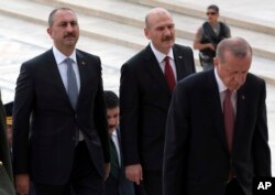 Justice Minister Abdulhamit Gul, left, and Interior Minister Suleyman Soylu, second left, follow President Recep Tayyip Erdogan during a ceremony at the mausoleum of Mustafa Kemal Ataturk, founder of modern Turkey, in Ankara, Aug. 2, 2018.