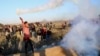 A Palestinian protester throws back a teargas canister that was fired by Israeli soldiers, during clashes on the Israeli border following a protest against U.S. President Donald Trump's decision to recognize Jerusalem as the capital of Israel, east of Gaz