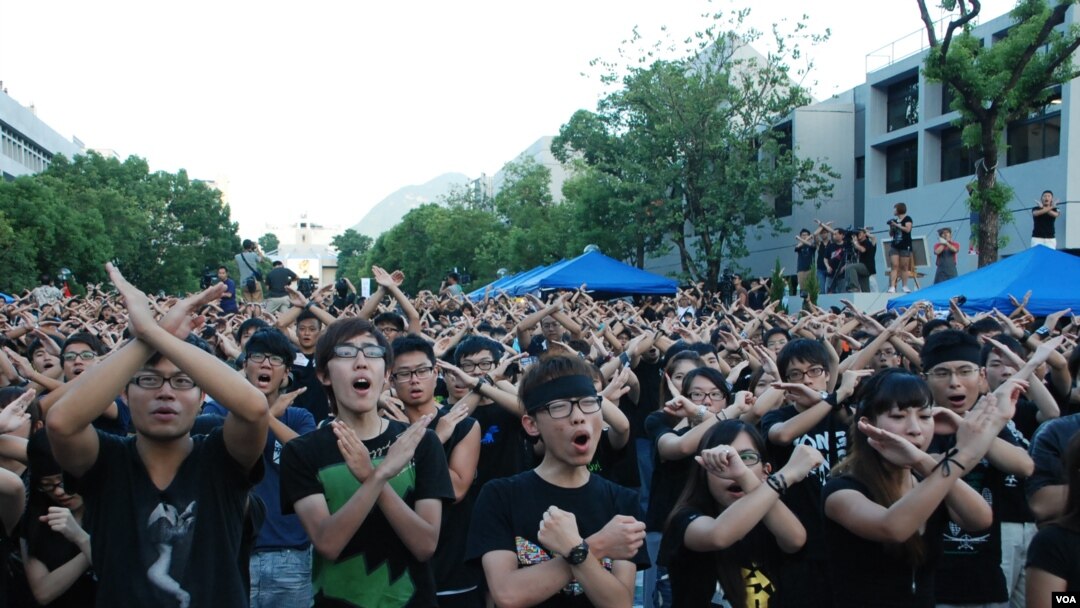 參加罷課的香港大專學生,一起做交叉手勢表達反對當局推行洗腦國民教育科