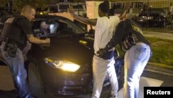 FILE - Cook County Sheriff police officers in Chicago, Illinois search a vehicle and a woman at street stop in the city's Austin neighborhood, September 9, 2015.