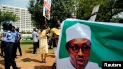 Wasu magoya bayan shugaba Buhari a rike da hotonsa yayin wani gangamin nuna goyon bayansa da aka yi a ranar 11 ga watan Agusta 2017 a Abuja