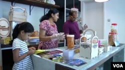 Sri Themudu, right, packages gift baskets for customers along with his wife, Praveena Sarva, and 7-year-old daughter, Diyaa. It’s a seasonal business for Deepavali, the Indian festival of lights. (Dave Grunebaum/VOA)