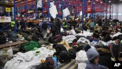 Migrants settle in a logistics center at the checkpoint "Kuznitsa" at the Belarus-Poland border near Grodno, Belarus, on Nov. 19, 2021.