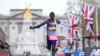 FILE - Kenya's Kelvin Kiptum breaks the tape to win the Men's race at the finish of the 2023 London Marathon in central London on April 23, 2023.