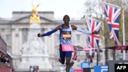 FILE - Kenya's Kelvin Kiptum breaks the tape to win the Men's race at the finish of the 2023 London Marathon in central London on April 23, 2023.