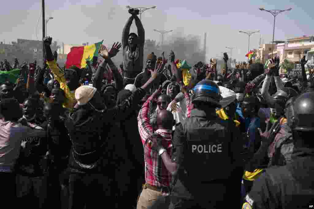 Demonstrators shout slogans in front of riot policemen during a protest against the arrest of opposition leader and former presidential candidate Ousmane Sonko, Senegal.