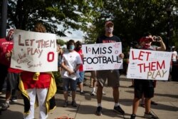 FILE - Fans attend a protest, staged by parents of Ohio State football players, against the cancellation of the Big Ten Conference's football season due to coronavirus concerns, outside Ohio State's stadium in Columbus, Ohio, Aug. 29, 2020.