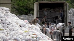 지난 2009년 북한 접경도시 신의주에서 북한 주민들이 중국으로부터 수입한 밀가루 포대를 트럭에 싣고 있다. 압록강 건너 중국 단둥에서 바라본 모습이다. (자료사진)