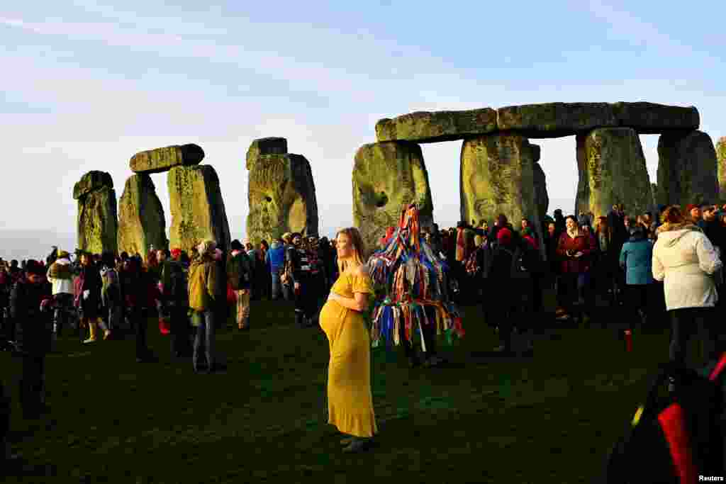 Ann Bloom, from Canada, joins revelers as they welcome in the winter solstice at Stonehenge stone circle, in Amesbury, Britain, Dec. 22, 2018.