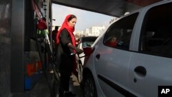 Una mujer llena su automóvil en una estación de servicio en Teherán, Irán, el viernes 15 de noviembre de 2019. Las autoridades impusieron el racionamiento y aumentaron los precios del combustible.