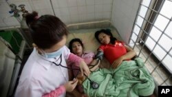 A Cambodian doctor checks blood pressure of patients at Preah Kossamak Hospital in Phnom Penh, Cambodia, file photo. (AP Photo/Sakchai Lalit)