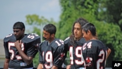 Samee Khan, 14, (second from left) abstains during a water break at football practice because he is observing the Ramadan fast.