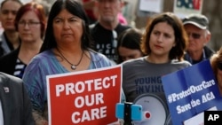 State Sen. Dr. Irene Aguilar, D-Denver, left, stands with activist Christina Postolowski, of the group Young Invincibles, as supporters of the Affordable Care Act who are also opponents of Colorado's GOP-led plan to undo Colorado's state-run insurance exc