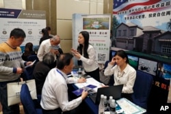Chinese visitors seek information of the U.S. government's EB-5 visa program at the exhibitor booths in a Invest in America Summit, a day after an event promoting EB-5 investment in a Kushner Companies development held at a hotel in Beijing.