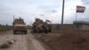 In this frame grab from video, an American military convoy is seen in the village of Khirbet Ammu, east of Qamishli city, Syria, Wednesday, Feb. 12, 2020. Syrian media and activists say a Syrian was killed and another wounded in a rare clash between…