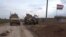 In this frame grab from video, an American military convoy is seen in the village of Khirbet Ammu, east of Qamishli city, Syria, Wednesday, Feb. 12, 2020. Syrian media and activists say a Syrian was killed and another wounded in a rare clash between…