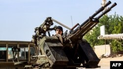 A Libyan fighter loyal to the Government of National Accord (GNA) mans a turret mounted on the back of a pickup truck during clashes with forces loyal to strongman Khalifa Haftar south of the capital Tripoli's suburb of Ain Zara, April 10, 2019. 