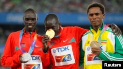 Abel Kirui du Kenya, au centre sur le podium, présente se médaille aux côtés de son compatriote Vincent Kipruto, médaillé d’argent, à gauche, et de l’Ethiopien Feyisa Lilesa, médaillé de bronze, à droite, après l'épreuve du marathon version masculine, aux Championnats du monde de l'IAAF à Daegu, 4 septembre 2011