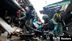 Personel militer memeriksa lokasi serangan bom, di sebuah pasar di Provinsi Yala, bagian selatan Thailand, 22 Januari. (REUTERS/Surapan Boonthanom)