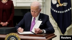 El presidente de EE.UU. Joe Biden firma órdenes ejecutivas en la Casa Blanca el 21 de enero de 2021.