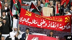 Protesters from opposition parties and labour unions hold a poster of Jordan's King Abdullah during a demonstration in Amman, January 28, 2011.