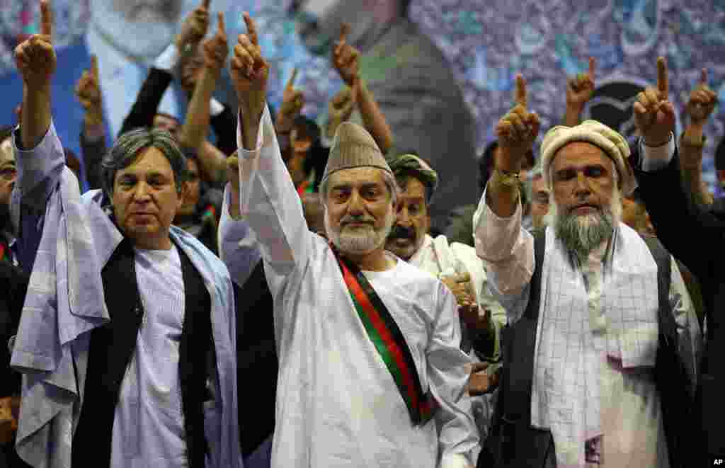 Presidential candidate Abdullah Abdullah, center, with his allies, raises his arm during his last campaign rally in Kabul, Afghanistan,&nbsp;June 11, 2014.
