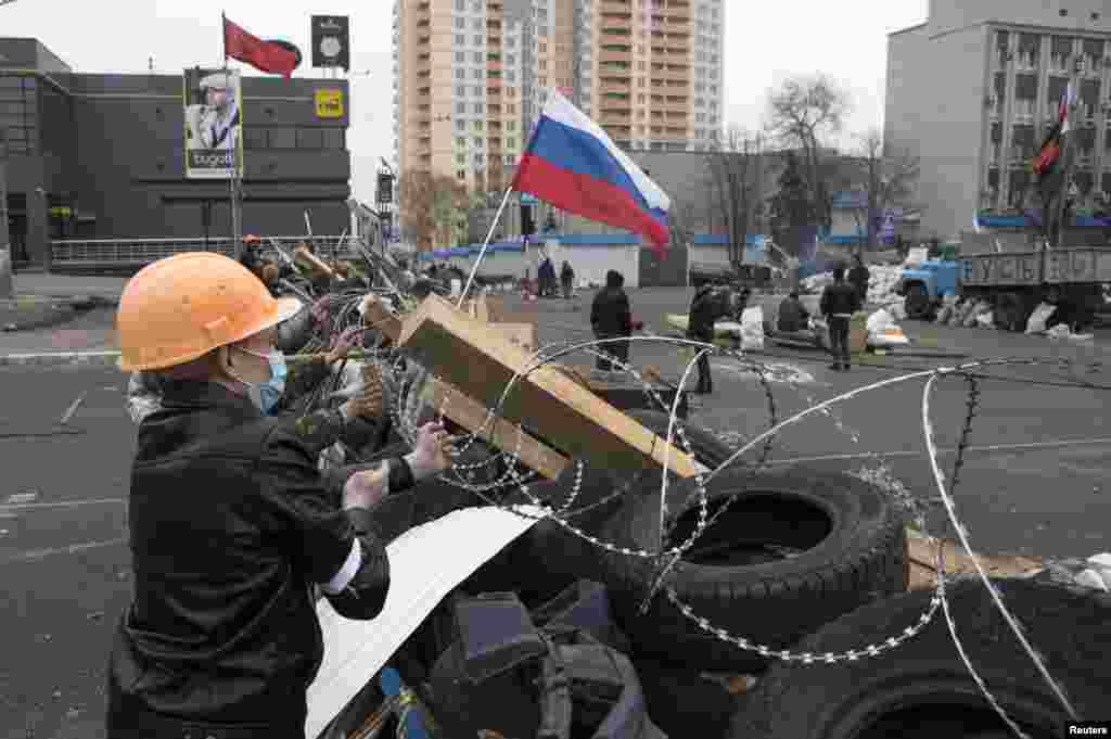 Pro-Russian protesters set barbed wire on a barricade outside the SBU state security service in Luhansk, Ukraine, April 10, 2014.