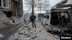 A man inspects his house, which was damaged by recent shelling, in the government-held village of Novoluhanske, Ukraine, Dec. 19, 2017. 