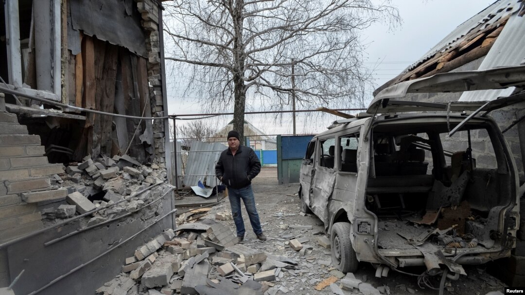 A man inspects his house, which was damaged by recent shelling, in the government-held village of Novoluhanske, Ukraine, Dec. 19, 2017. 