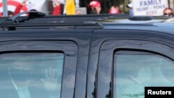 ປະທານາທິບໍດີ ດໍໂນລ ທຣຳ ຂີ່ລົດຜ່ານໜ້າສູນກາງການແພດທະຫານແຫ່ງຊາດ Walter Reed, ບ່ອນທີ່ທ່ານກຳລັງໄດ້ຮັບການປິ່ນປົວ COVID-19, ເມືອງ ເບເຕັສດາ, ລັດ ແມຣີແລນ. 4 ຕຸລາ, 2020.