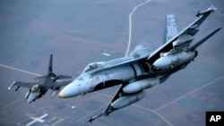 FILE - A Portuguese military fighter jet, left, and a Canadian military fighter jet participate in NATO's Baltic Air Policing Mission in Lithuanian airspace, Nov. 20, 2014.