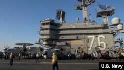 Aircraft handlers direct a C-2A Greyhound assigned to Fleet Logistics Support Squadron (VRC) 30 on the flight deck of the aircraft carrier, USS Ronald Reagan in the Western Pacific Ocean, Nov. 13, 2017.