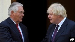 Britain's Foreign Secretary Boris Johnson, right, shakes hands with US Secretary of State, Rex Tillerson, outside Carlton Gardens in London, Friday May 26, 2017, ahead of their meeting. 