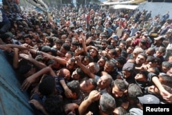 Palestinians gather to buy bread from a bakery, amid the Israel-Hamas conflict, in Deir Al-Balah in the central Gaza Strip, Oct. 24, 2024.