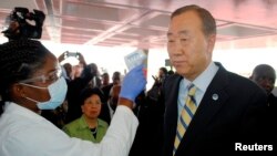 Sekjen PBB Ban Ki-moon diperiksa suhu tubuhnya saat tiba di bandar udara di Monrovia, Liberia (19/12). (Reuters/James Giahyue)