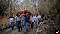 Para anggota kelompok pencarian Solecito menggotong peti jenazah Pedro Huesca, detektif yang menghilang di 2013 dan mayatnya ditemukan dalam kuburan massal, ke pemakaman Palmas de Abajo, di Veracruz, Meksiko (8/3). (AP/Felix Marquez)